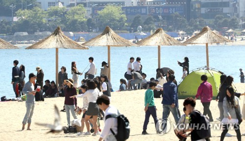 (부산=연합뉴스) 조정호 기자 = 징검다리 연휴이자 부처님 오신날인 3일 오후 부산 광안리해수욕장에서 나들이객들이 갈대 파라솔 아래에서 더위를 식히며 휴일을 만끽하고 있다. 2017.5.3. ccho@yna.co.kr