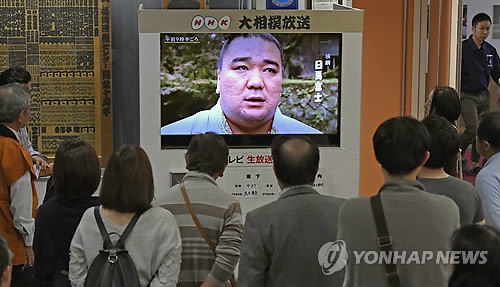 (후쿠오카 교도=연합뉴스) 일본 후쿠오카(福岡)현 후쿠오카시민들이 대형 TV를 통해 방송되는 스모(相撲·일본 씨름) 요코즈나(橫網·스모의 가장 높은 등급 장사) 하루마후지(日馬富士·33) 선수의 맥주병 폭행 소식을 지켜보고 있다. 2017.11.15 choinal@yna.co.kr