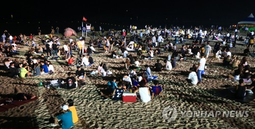 (강릉=연합뉴스) 이종건 기자 = 연일 이어지는 폭염과 열대야 속에 주말인 21일 밤 자정이 가까워져 오는 늦은 시간임에도 경포해수욕장 백사장이 인파로 북적이고 있다. 2018.7.22 momo@yna.co.kr