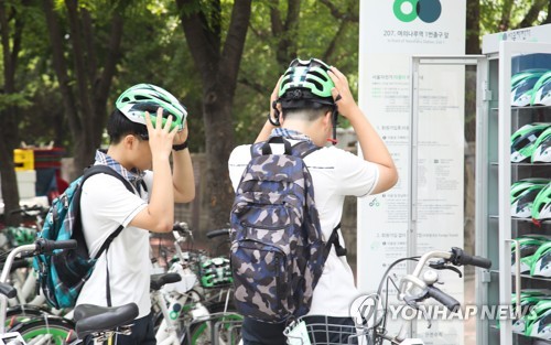 (서울=연합뉴스) 류효림 기자 = 서울시 공공자전거 따릉이를 운영하는 서울시설공단은 자전거 헬멧 착용 의무화를 앞두고 20일부터 출·퇴근 시간에 따릉이 이용률이 높은 여의도에서 헬멧 무료 대여를 시범운영 한다고 밝혔다. 이날 오후 서울 여의도 지하철5호선 여의나루역 1번 출구 앞 따릉이 대여소에서 청소년들이 따릉이를 대여하며 헬멧을 써보고 있다. 2018.7.20 ryousanta@yna.co.kr (끝)