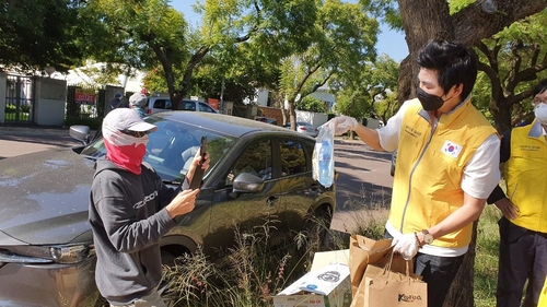 (요하네스버그=연합뉴스) 김성진 특파원 = 12일(현지시간) 남아공 프리토리아 주재 카타르 대사관 앞에서 한 프랑스 탑승객이 한국 대사관이 준비한 교민 환송 물품을 부럽다면서 사진 찍고 있다. sungjin@yna.co.kr
