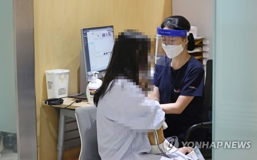 (서울=연합뉴스) 류영석 기자 = 정부가 독감 백신의 유통상 문제로 무료접종 사업을 일시 중단한 가운데 23일 오전 서울 강서구 한국건강관리협회 건강증진의원 서울서부지부를 찾은 시민이 유료 독감 예방접종을 받고 있다. 2020.9.23 ondol@yna.co.kr