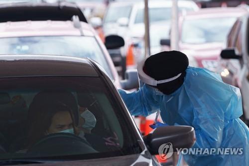 미 텍사스주 엘패소의 드라이브스루 코로나19 검사소에서 한 의료 요원이 검사를 하고 있다. [로이터=연합뉴스]