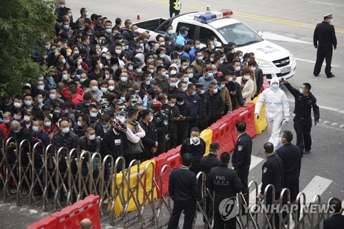 (상하이 AP=연합뉴스) 23일 중국 상하이 푸둥 국제공항에서 마스크를 착용한 공항 노동자들이 신종 코로나바이러스 감염증(코로나19) 검사를 받기 위해 대기 중인 가운데 경찰과 보안요원들이 경비를 서고 있다. 중국 방역 당국은 상하이에서 푸둥 국제공항 노동자를 중심으로 코로나19 확진자가 사흘 연속 나오자 시내 주거구역 3곳을 봉쇄하고 전 주민 대상 검사를 했다. leekm@yna.co.kr