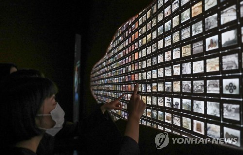 (서울=연합뉴스) 류효림 기자 = 30일 서울 종로구 국립고궁박물관에서 열린 '고궁연화, 경복궁 발굴·복원 30주년 기념 특별전' 언론 공개회에서 참석자들이 경복궁 발굴·복원 과정이 담긴 슬라이드 필름을 살펴보고 있다.