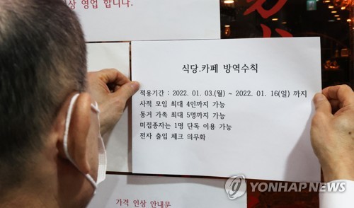 (서울=연합뉴스) 최재구 기자 = 3일 서울 한 식당에서 관계자가 방역안내문을 출입문에 부착하고 있다. 이날부터 방역패스 6개월 유효기간이 적용된다. 지난해 7월 6일 전에 기본접종 후 추가접종을 하지 않았다면 방역패스 적용 시설에 입장할 수 없다. 2022.1.3 jjaeck9@yna.co.kr