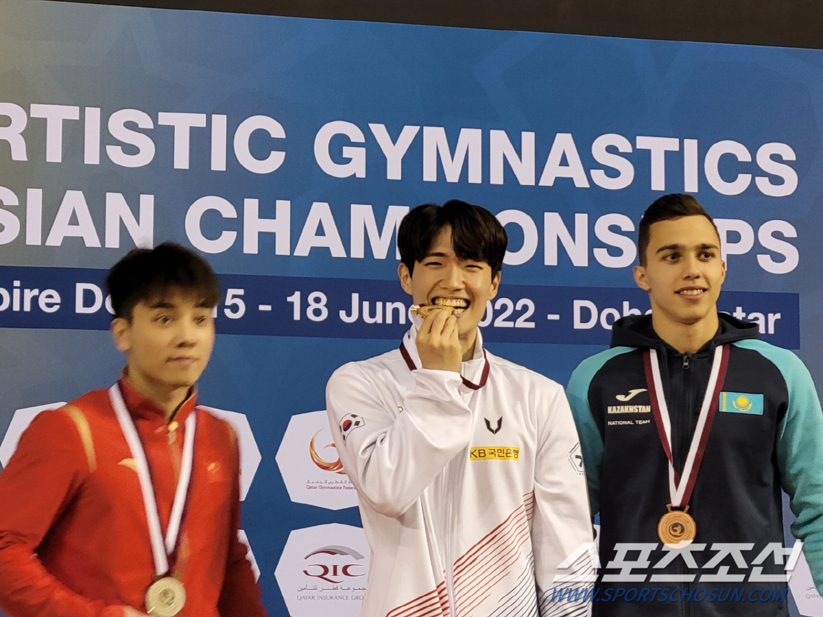 윤진성이 19일 카타르 도하 아시아선수권에서 철봉 금메달 획득 후 활짝 웃으며 메달을 깨무는 포즈를 취하고 있다. 사진제공=대한체조협회