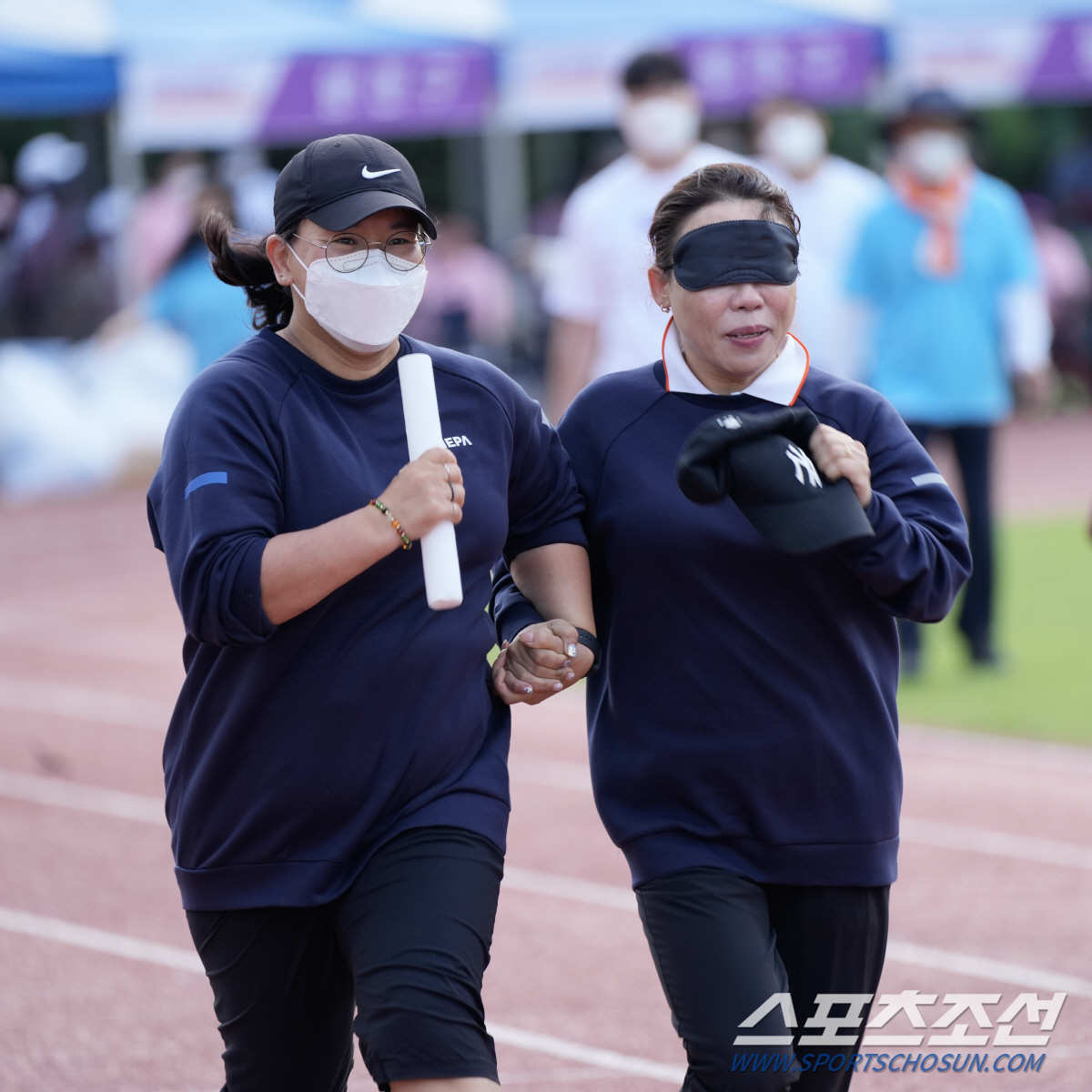 20일 서울 잠실종합운동장 보조경기장에서 열린 '2022년 서울특별시장애인생활체육대회' '단체 릴레이'에서 시각장애인 동호인 선수(오른쪽)가 가이드러너와 질주하고 있다. 사진 제공=서울시장애인체육회