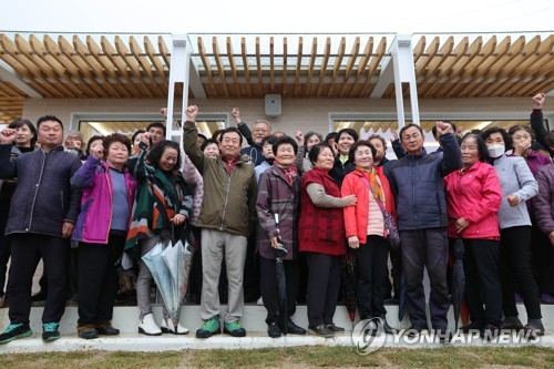 (양산=연합뉴스) 김동민 기자 = 문재인 전 대통령 내외가 25일 오후 경남 양산시 하북면 평산마을 '평산 책방'에서 열린 현판식에 참석해 마을 주민들과 기념사진을 찍고 있다. 2023.4.25 [공동 취재] image@yna.co.kr