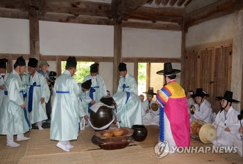 (강릉=연합뉴스) 유형재 기자 = 24일 강원 강릉시 옛 관아인 칠사당에서 열린 강릉단오제 신주 빚기 행사에서 제관들이 정성을 다해 술을 빚고 있다. 이날 빚은 술은 강릉단오제 기간 각종 제례 등에 사용된다. 2023 강릉단오제는 '단오, 보우하사'를 주제로 6월 18일부터 25일까지 강릉시 남대천 행사장에서 펼쳐진다. 2023.5.24 yoo21@yna.co.kr