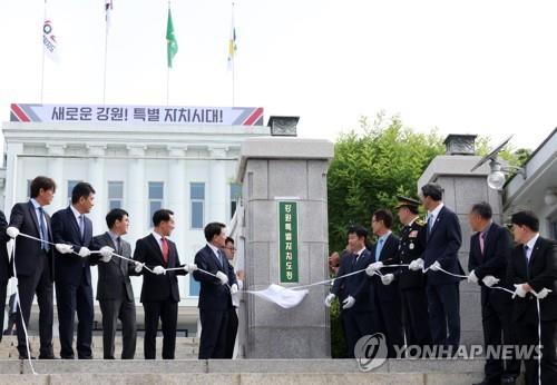 (춘천=연합뉴스) 양지웅 기자 = 12일 강원 춘천시 강원특별자치도청에서 열린 강원특별자치도청·도의회 현판식에서 김진태 도지사와 실·국·과장 등 참석자들이 가림막을 떼어내고 있다. 2023.6.12 yangdoo@yna.co.k