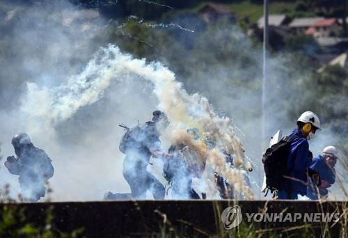 (모리엔느 AFP=연합뉴스) 17일(현지시간) 프랑스 알프스 모리엔느 계곡 인근에서 열린 리옹-토리노 간 고속철도 건설 반대 시위에서 시위대가 경찰의 최루탄을 피해 달아나는 모습. 2023.06.17