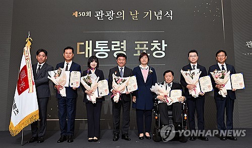 (서울=연합뉴스) 장미란 문화체육관광부 제2차관이 4일 서울 중구 롯데호텔 서울에서 열린 제50회 관광의 날 기념식에 참석해 관광 유공 대통령 표창을 수여 후 수상자들과 기념 촬영하고 있다. 2023.10.4 [문화체육관광부 제공. 재판매 및 DB 금지] photo@yna.co.kr