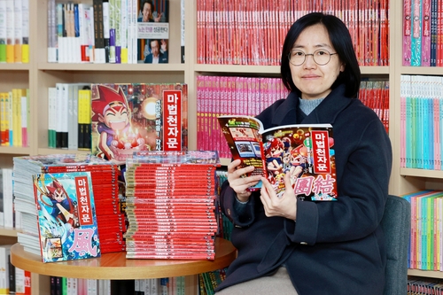 (서울=연합뉴스) 진연수 기자 = 은지영 북이십일 키즈융합부문 이사가 서울 마포구의 사무실에서 국내 최장수 학습만화 '마법천자문'과 함께 포즈를 취하고 있다. 2023.12.23 jin90@yna.co.kr