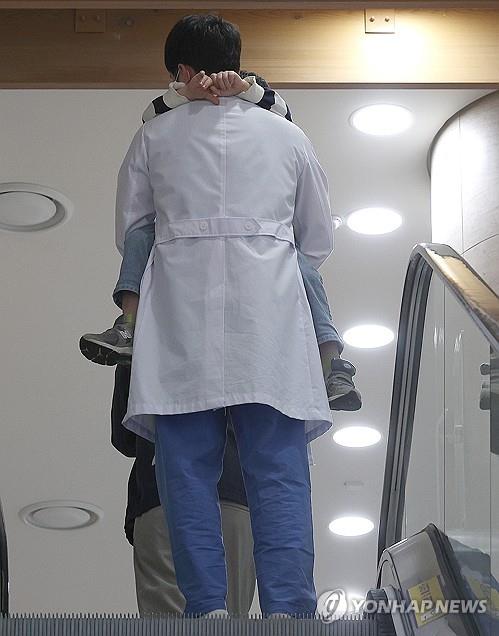 한 대학병원에서 의료관계자가 아이를 안고 이동하고 있다.