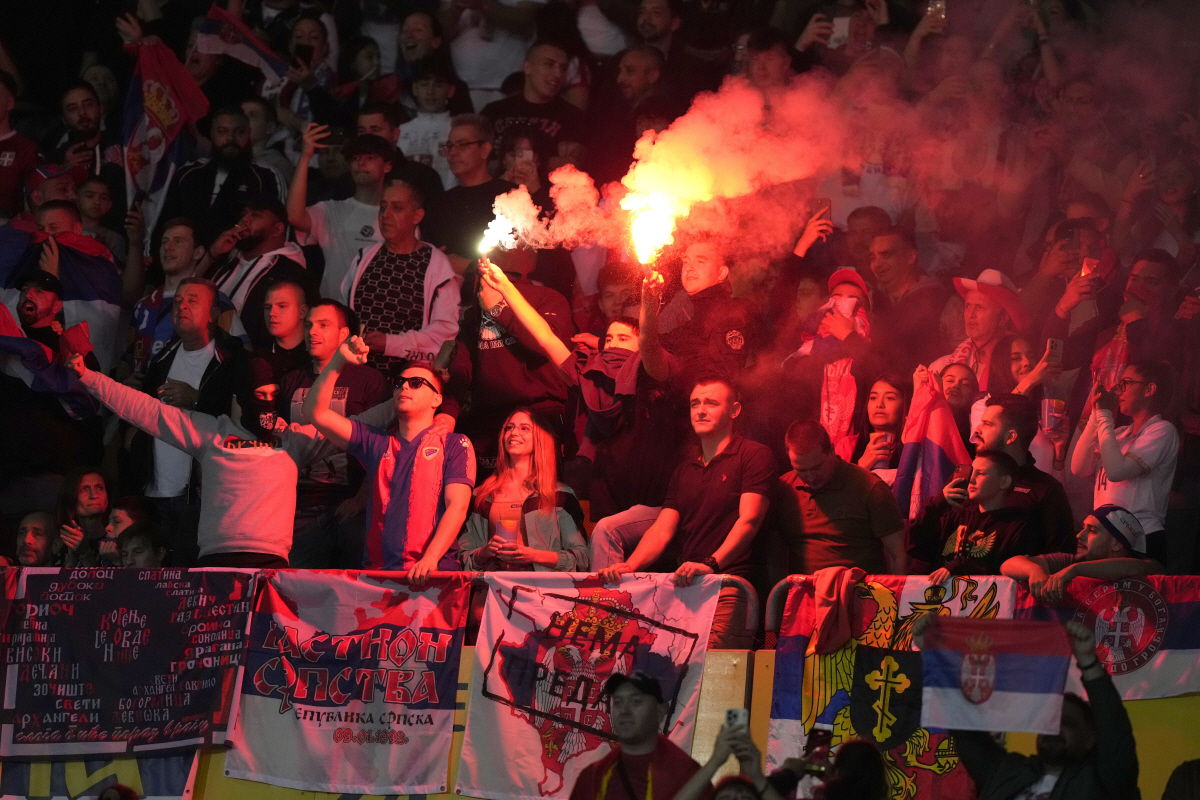 FILE -Serbia fans lit flares during an international friendly soccer match between Austria and Serbia at the Ernst Happel Stadion in Vienna, Austria, Tuesday, June 4, 2024. A recent surge in violence around soccer games is contributing to alarm over security when Germany hosts the European Championship. (AP Photo/Matthias Schrader, File) FILE PHOTO