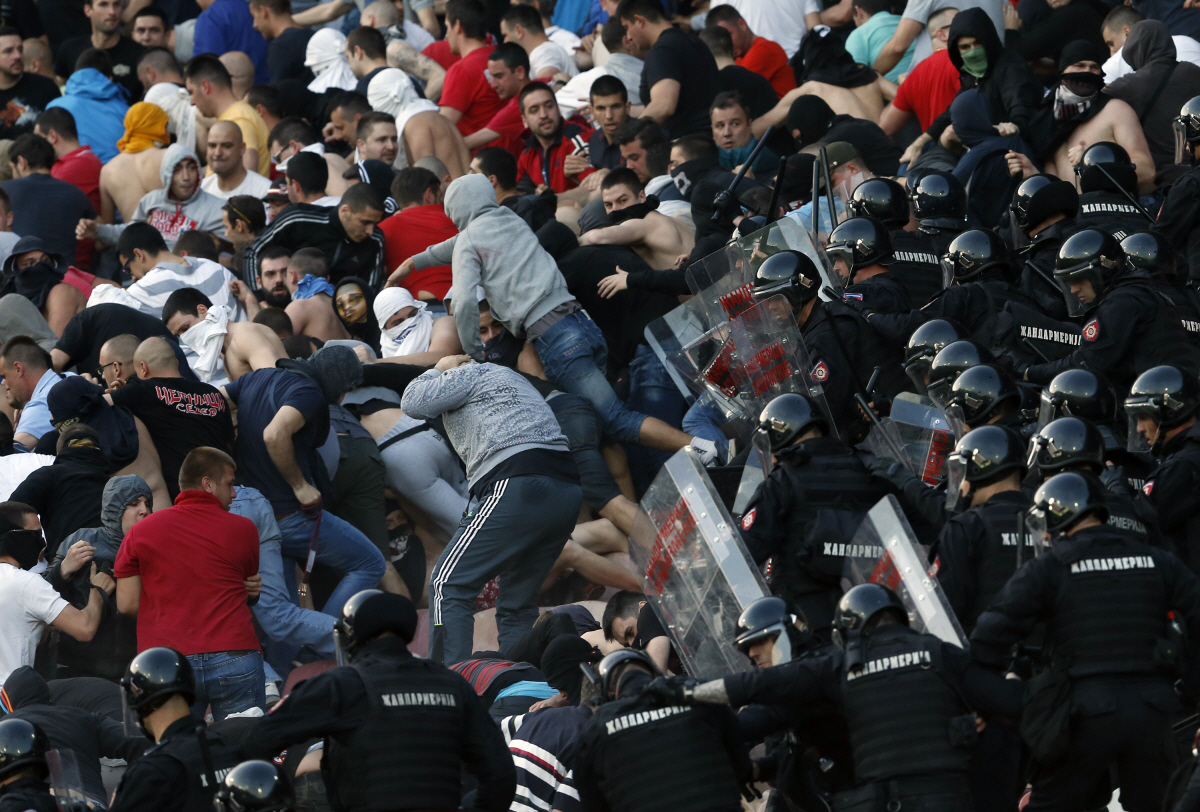 FILE - In this Saturday, April 16, 2016 file photo, Serbian riot police officers clash with Red Star soccer fans during a Serbian National soccer league match between Red Star and Partizan, in Belgrade. A recent surge in violence around soccer games is contributing to alarm over security when Germany hosts the European Championship. (AP Photo/Darko Vojinovic, File) SATURDAY, APRIL 16, 2016 FILE PHOTO