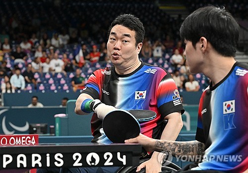 (서울=연합뉴스) 장애인 탁구 대표팀의 박성주가 29일(현지시간) 프랑스 파리 사우스 파리 아레나에서 열린 2024 파리 패럴림픽 탁구 남자 복식 8강전 영국과의 경기에서 장영진과 탁구채로 하이파이브를 하고 있다. 2024.8.29 [사진공동취재단] photo@yna.co.kr