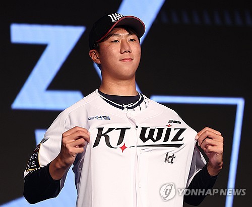 (서울=연합뉴스) 류영석 기자 = 11일 오후 서울 송파구 롯데호텔 월드 크리스탈볼룸에서 열린 2025 KBO 신인 드래프트에서 kt wiz에 1라운드 9순위 지명을 받은 김동현(서울고)이 유니폼을 입고 기념촬영을 하고 있다. 2024.9.11 ondol@yna.co.kr