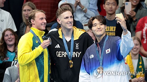 (파리=연합뉴스) 김인철 기자 = 27일(현지시간) 프랑스 파리 라데팡스 아레나에서 열린 2024 파리올림픽 수영 남자 자유형 400m 결승에서 동메달을 차지한 김우민이 삼성 Z플립6로 셀카를 촬영하고 있다. 2024.7.28 yatoya@yna.co.kr