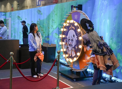 (고양=연합뉴스) 김주환 기자 = 31일 오전 경기 고양시 킨텍스에서 호요버스코리아가 개최한 '웰컴 호요랜드' 행사장 내 '원신' 부스에서 게임 캐릭터로 코스프레를 한 관람객이 돌림판 미니게임을 즐기고 있다. 2024.10.31 jujuk@yna.co.kr