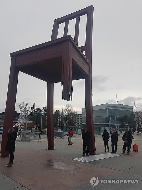 (제네바=연합뉴스) 이광철 특파원 = 이달 3일 대인지뢰금지협약(오타와 협약) 채택 20주년을 맞은 가운데 20일(현지시간) 유엔 제네바 사무국 앞에 설치된 '부러진 의자' 앞에 관광객들이 모여 있다. 2017.12.21 photo@yna.co.kr