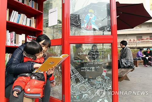 (서울=연합뉴스) 이지은 기자 = 서울 성동구 왕립리역 앞 광장에 위치한 책뜨락에서 한 어린이와 엄마가 책을 보고 있다. 2012.3.7