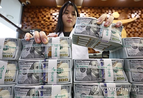 (서울=연합뉴스) 김성민 기자 = 10일 서울 중구 명동 KEB하나은행 위변조대응센터에서 직원이 미국 달러를 들어 보이고 있다. 원/달러 환율은 이날 미국 달러화 강세 등 추석 연휴 기간 주요 변수를 한꺼번에 소화하며 1420원대까지 급등했다. 2025.10.10 ksm7976@yna.co.kr