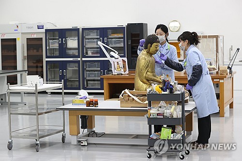 (서울=연합뉴스) 강민지 기자 = 28일 서울 용산구 국립중앙박물관에서 보존과학센터 목재실 관계자들이 목재 불상 건식세척을 하고 있다. 센터는 국립중앙박물관 용산 이전 20주년을 맞아 개관했다. 2025.10.28 mjkang@yna.co.kr
