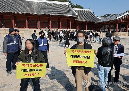 (서울=연합뉴스) 류영석 기자 = 최휘영 문화체육관광부 장관과 허민 국가유산청장이 7일 서울 종묘에서 종묘 앞 개발 규제 완화 관련 대법원 판결에 대한 입장 발표 기자회견을 준비 중인 가운데 세운 4구역 주민이 대법원 판결 이행 촉구 팻말을 들고 항의하고 있다. 지난 6일 대법원은 문화유산법 해석상 역사문화환경 보존지역 바깥에 대해서까지 국가유산청과 협의해 조례를 정해야 한다고 볼 수는 없다며 개발 규제를 완화한 서울시 조례 개정이 법령 우위 원칙(법령이 조례보다 위에 있다는 원칙)에 위반되지 않는다고 판단했다. 2025.11.7 ondol@yna.co.kr