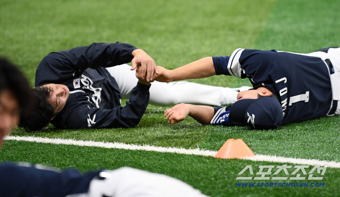 스트레칭할 때도 두손 꼬옥...대표팀 에이스는 어쩌다 162km 후배의 '애착 인형'이 됐나