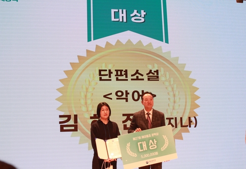 (서울=연합뉴스) 박현수 기자 = 19일 서울 종로구 교원투어콘서트홀에서 열린 제27회 재외동포문학상 시상식에서 단편소설 부문 대상을 받은 김혜진(왼쪽) 작가가 변철환 재외동포청 차장과 기념촬영을 하고 있다. 2025.11.19. phyeonsoo@yna.co.kr
