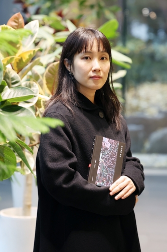 (서울=연합뉴스) 진연수 기자 = 함윤이 작가가 지난 24일 서울 종로구 연합뉴스에서 진행된 인터뷰에 앞서 최근 펴낸 첫 소설집 '자개장의 용도'를 들고 포즈를 취하고 있다. 2025.11.26