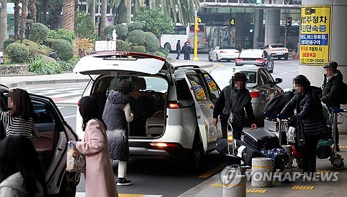 (제주=연합뉴스) 박지호 기자 = 제주국제공항 도착층 불법주정차 단속유예 시간이 5분에서 1분으로 단축된 1일 오전 제주국제공항 도착층 앞 도로에서 이용객들이 승합차에 짐을 싣고 있다. 2025.12.1 jihopark@yna.co.kr