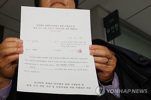 (서울=연합뉴스) 신현우 기자 = 17일 김건희특검팀이 압수수색에 나선 국회의원회관 내 김 의원 사무실 앞에서 김 의원 법률대리인 윤용근 변호사가 '사무실을 수색한 결과 증거물 또는 몰수할 물건이 없음을 증명합니다'고 적힌 증명서를 보이고 있다. 2025.12.17 nowwego@yna.co.kr
