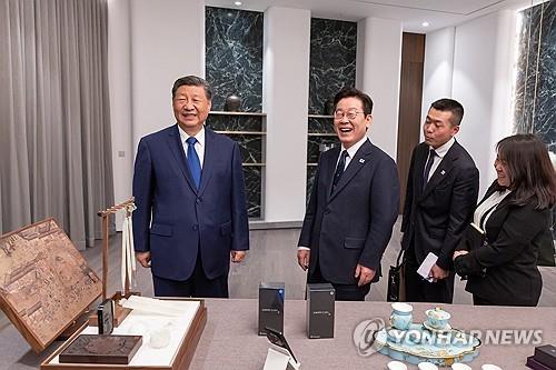 (경주=연합뉴스) 이재명 대통령과 시진핑 중국 국가주석이 1일 경북 소노캄 호텔에서 국빈만찬 전 갖은 친교 시간에 한중 정상이 서로를 위해 준비한 선물을 보고 있다. 이날 이 대통령은 시 주석에게 본비자나무로 제작된 바둑판과 조각 받침대, 나전칠기 자개원형쟁반을 선물했고 시 주석은 이 대통령에게 중국 브랜드인 샤오미 스마트폰과 문방사우 세트를 선물했다. 2025.11.2 [대통령실 제공. 재판매 및 DB 금지] photo@yna.co.kr