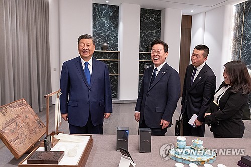 (경주=연합뉴스) 이재명 대통령과 시진핑 중국 국가주석이 1일 경북 소노캄 호텔에서 국빈만찬 전 갖은 친교 시간에 한중 정상이 서로를 위해 준비한 선물을 보고 있다. 이날 이 대통령은 시 주석에게 본비자나무로 제작된 바둑판과 조각 받침대, 나전칠기 자개원형쟁반을 선물했고 시 주석은 이 대통령에게 중국 브랜드인 샤오미 스마트폰과 문방사우 세트를 선물했다. 2025.11.2 [대통령실 제공. 재판매 및 DB 금지] photo@yna.co.kr