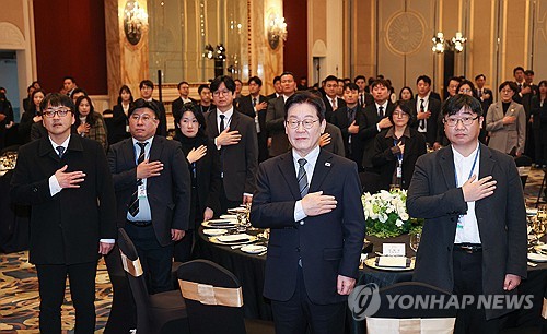 (상하이=연합뉴스) 한상균 기자 = 중국을 국빈방문 중인 이재명 대통령이 7일 상하이의 한 호텔에서 열린 순방 기자단 오찬 간담회에서 국기에 경례하고 있다. 2026.1.7 xyz@yna.co.kr