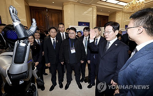 (상하이=연합뉴스) 한상균 기자 = 이재명 대통령이 7일 중국 상하이 국제회의중심에서 열린 한·중 벤처스타트업 서밋에서 중국 업체가 만든 휴머노이드 로봇과 인사하고 있다. 2026.1.7 xyz@yna.co.kr