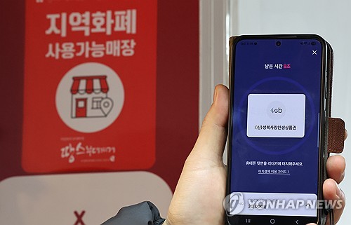 (서울=연합뉴스) 이진욱 기자 = 지난 2일 국회 본회의에서 처리된 내년도 예산안에서 이재명 정부의 역점 사업인 지역사랑상품권 발행 지원(1조1천500억원)은 원안 유지됐다. 사진은 3일 서울 성북구 한 재래시장 상점에 붙은 지역화폐 사용 가능 안내문과 모바일 성북사랑민생상품권 모습. 2025.12.3 cityboy@yna.co.kr