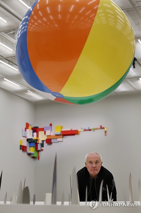 (서울=연합뉴스) 이재희 기자 = 영국 작가 데이미언 허스트가 18일 서울 종로구 국립현대미술관에서 열린 '진실은 없어 그러나 모든 것은 가능하지' 개인전에 전시된 '사랑의 취약성' 작품과 함께 포즈를 취하고 있다. 2026.3.18 scape@yna.co.kr