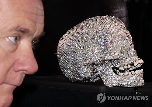 (서울=연합뉴스) 이재희 기자 = 영국 작가 데이미언 허스트가 18일 서울 종로구 국립현대미술관에서 열린 '진실은 없어 그러나 모든 것은 가능하지' 개인전에 전시된 '신의 사랑을 위하여' 작품 앞에서 포즈를 취하고 있다. 2026.3.18 scape@yna.co.kr