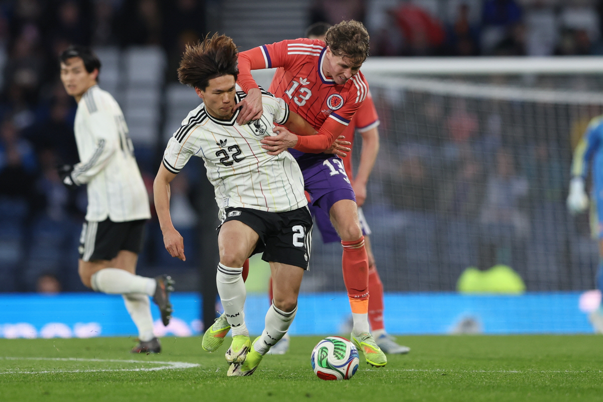 Japan's Kento Shiogai, left, challenges for the ball with Scotland's Jack Hendry during the international friendly soccer match between Scotland and Japan in Glasgow, Scotland, Saturday, March 28, 2026. (AP Photo/Scott Heppell)