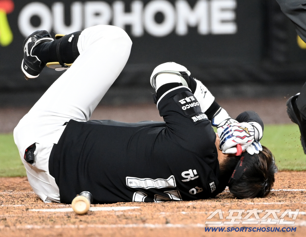허경민이 엄상백의 투구를 머리에 맞고 얼굴을 두 손으로 감싸쥔 채 쓰러져 있다.