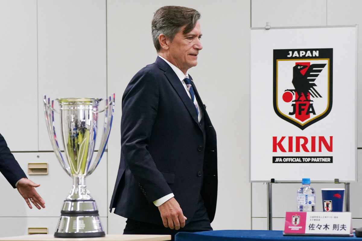 Japan women's national football team head coach Nils Nielsen walks past the trophy at the beginning of the press conference following Japan's victory in the AFC Women's Asian Cup Australia 2026 football tournament, in Tokyo on March 23, 2026. (Photo by Kazuhiro NOGI / AFP)