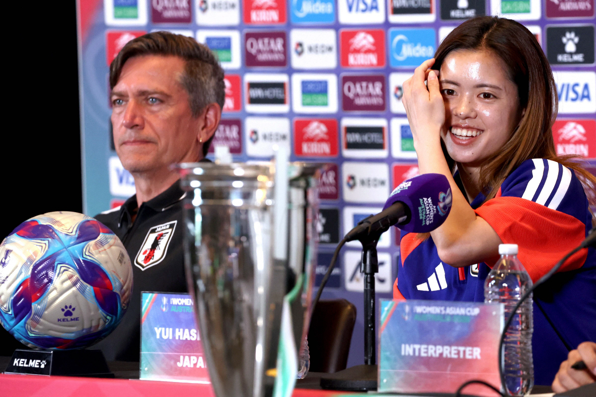 Japan?s head coach Nils Nielsen (L) listens as captain Yui Hasegawa speaks during a press conference in Sydney on March 20, 2026 ahead of the 2026 AFC Women?s Asian Cup final between Japan and Australia on March 21. (Photo by DAVID GRAY / AFP) / - IMAGE RESTRICTED TO EDITORIAL USE - STRICTLY NO COMMERCIAL USE -