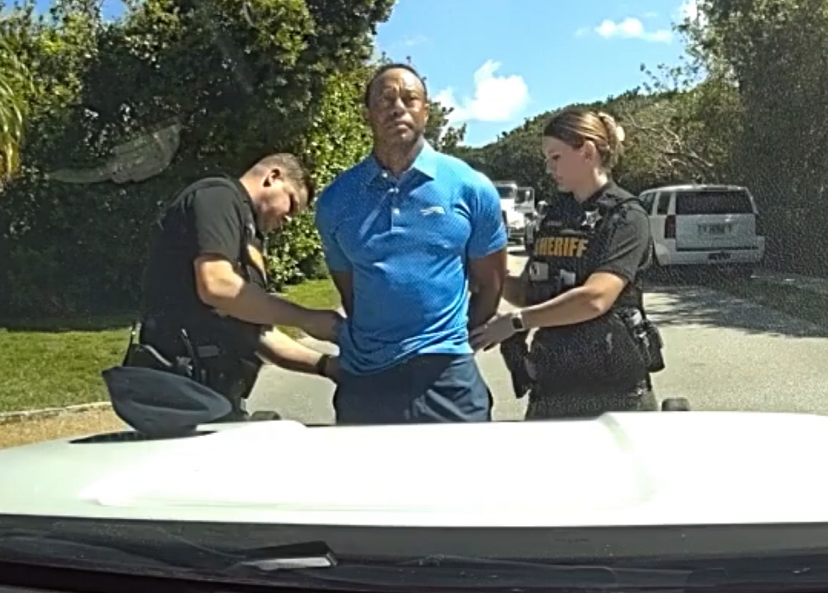 In this image from police body camera video released by the Martin County, Fla., Sheriff's Office, golfer Tiger Woods is taken into custody by sheriff's deputies following a car crash in Jupiter Island, Fla., Friday, March 27, 2026. (Martin County Sheriff's Office via AP) AP PROVIDES ACCESS TO THIS PUBLICLY DISTRIBUTED HANDOUT PHOTO PROVIDED BY THE MARTIN COUNTY SHERIFF'S OFFICE; MANDATORY CREDIT. IMAGE TAKEN FROM POLICE BODY CAMERA VIDEO