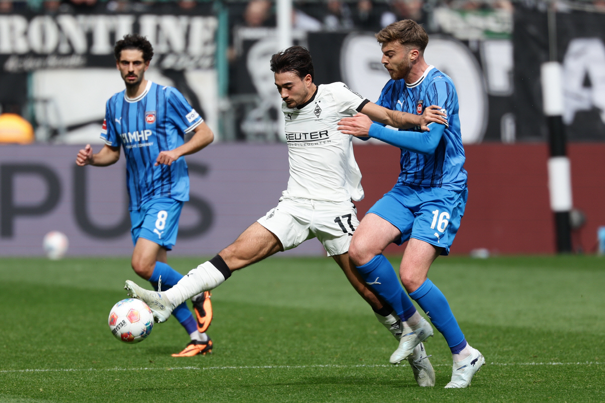 (260405) -- MOENCHENGLADBACH, April 5, 2026 (Xinhua) -- Jens Castrop (C) of Borussia Moenchengladbach vies with Julian Niehues (R) of 1. FC Heidenheim 1846 during the German first division of Bundesliga football match between Borussia Moenchengladbach and 1. FC Heidenheim 1846 in Moenchengladbach, Germany, April 4, 2026. (Photo by Joachim Bywaletz/Xinhua)