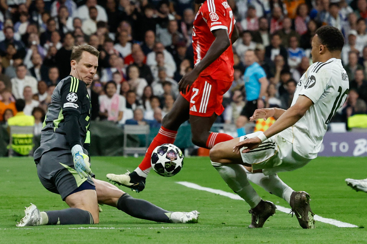 Real Madrid's French forward #10 Kylian Mbappe (R) shoots but fails to score past Bayern Munich's German goalkeeper #01 Manuel Neuer during the UEFA Champions League quarter final first leg football match between Real Madrid CF and FC Bayern Munich at Santiago Bernabeu Stadium in Madrid on April 7, 2026. (Photo by Oscar DEL POZO / AFP)
