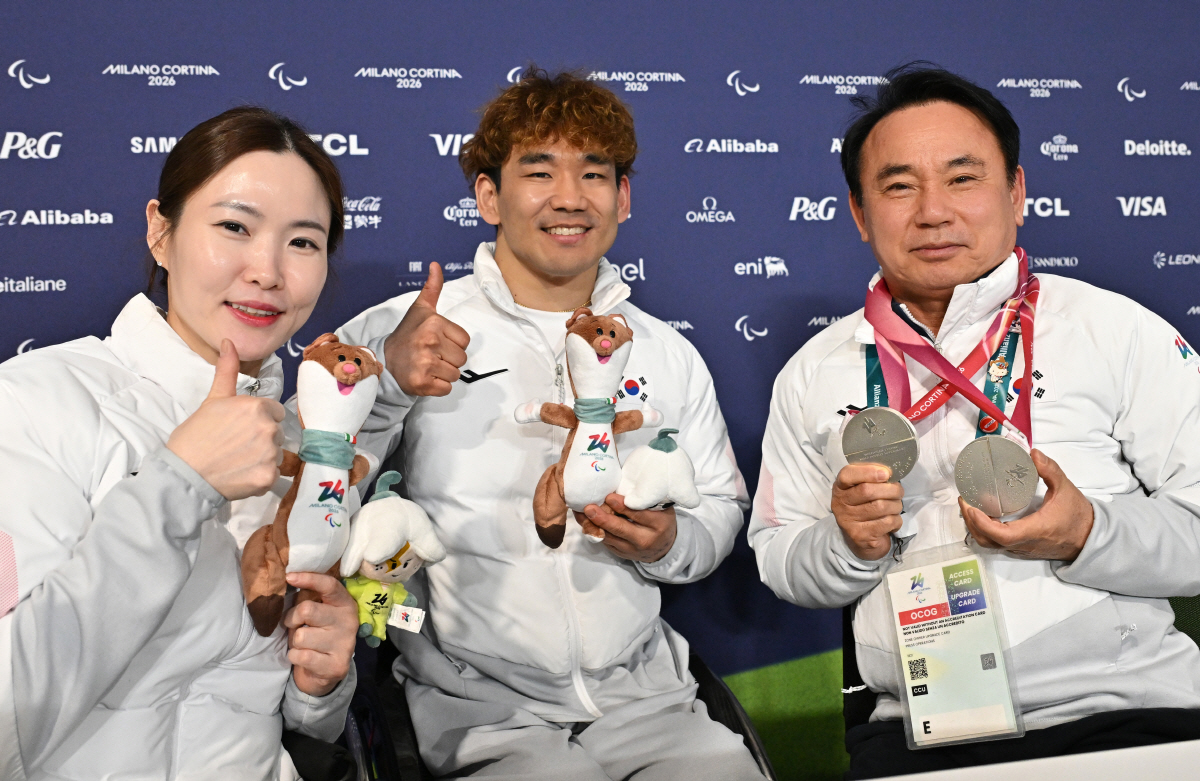 윤경선 대한장애인컬링협회장(오른쪽 끝)이 12일(한국시각) 이탈리아 코르티나 컬링 올림픽 스타디움에서 열린 2026년 밀라노-코르티나 동계 패럴림픽 휠체어컬링 믹스더블에서 16년 만에 은메달을 획득한 백혜진-이용석이 은메달 2개를 걸어주자 감격의 눈물을 글썽이고 있다.